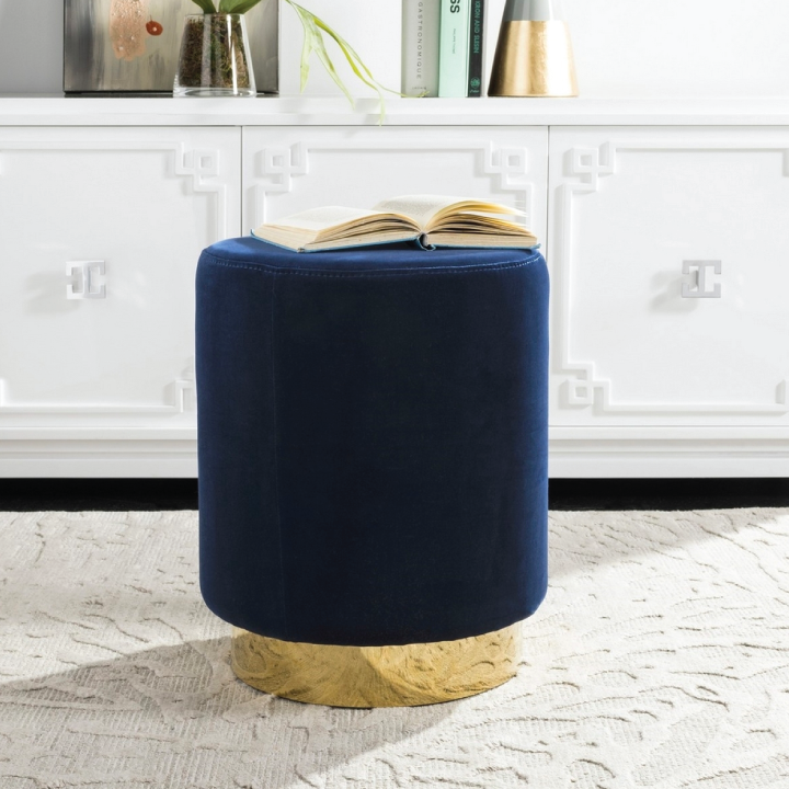 navy blue ottoman with brass base in living space